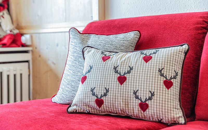 Rote Couch mit Kissen - Newsletter Hotel Saigerhöh