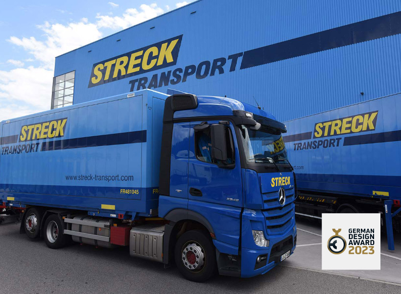 LKW und Wechselbrücke von Streck Transport vor Logistikgebäude mit Award