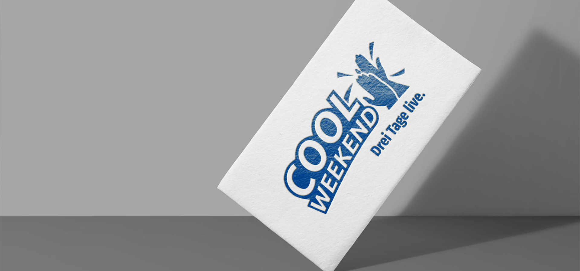 Ansicht der Rückseite der Visitenkarte von Cool Weekend vor dunkelgrauem Hintergrund