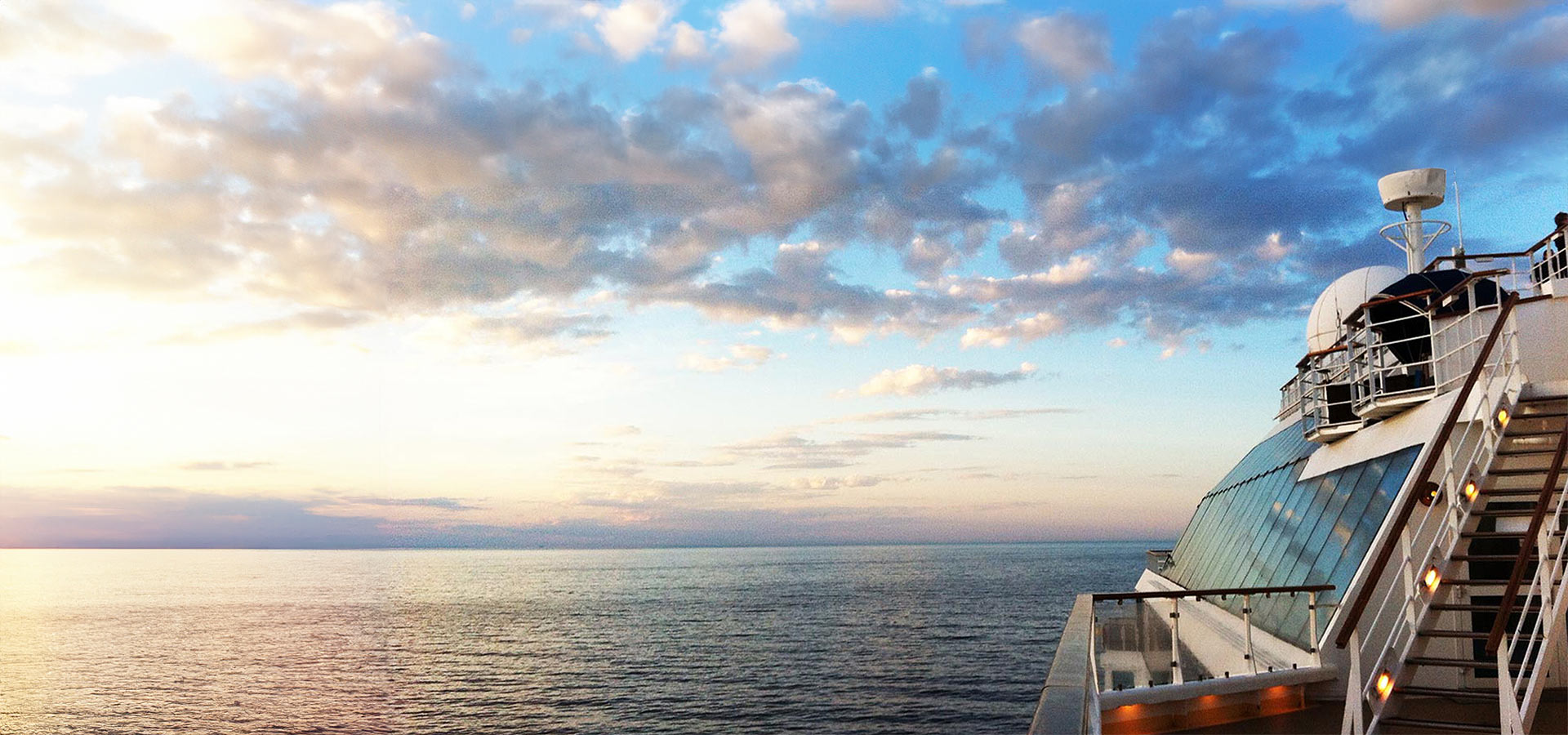 Blick vom Deck eines Kreuzfahrtschiffs auf offener See bei Sonnenuntergang