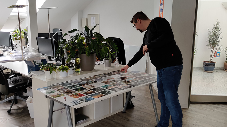 Workshopsituation mit einer Person, die sich vorbeugt, um ein Bild auszuwählen