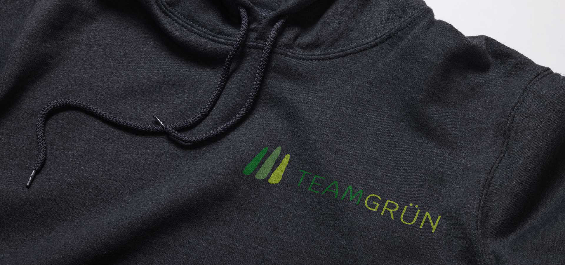Nahaufnahme eines schwarzen Hoodies mit dem Logo von Team Grün in Farbe auf der Brust