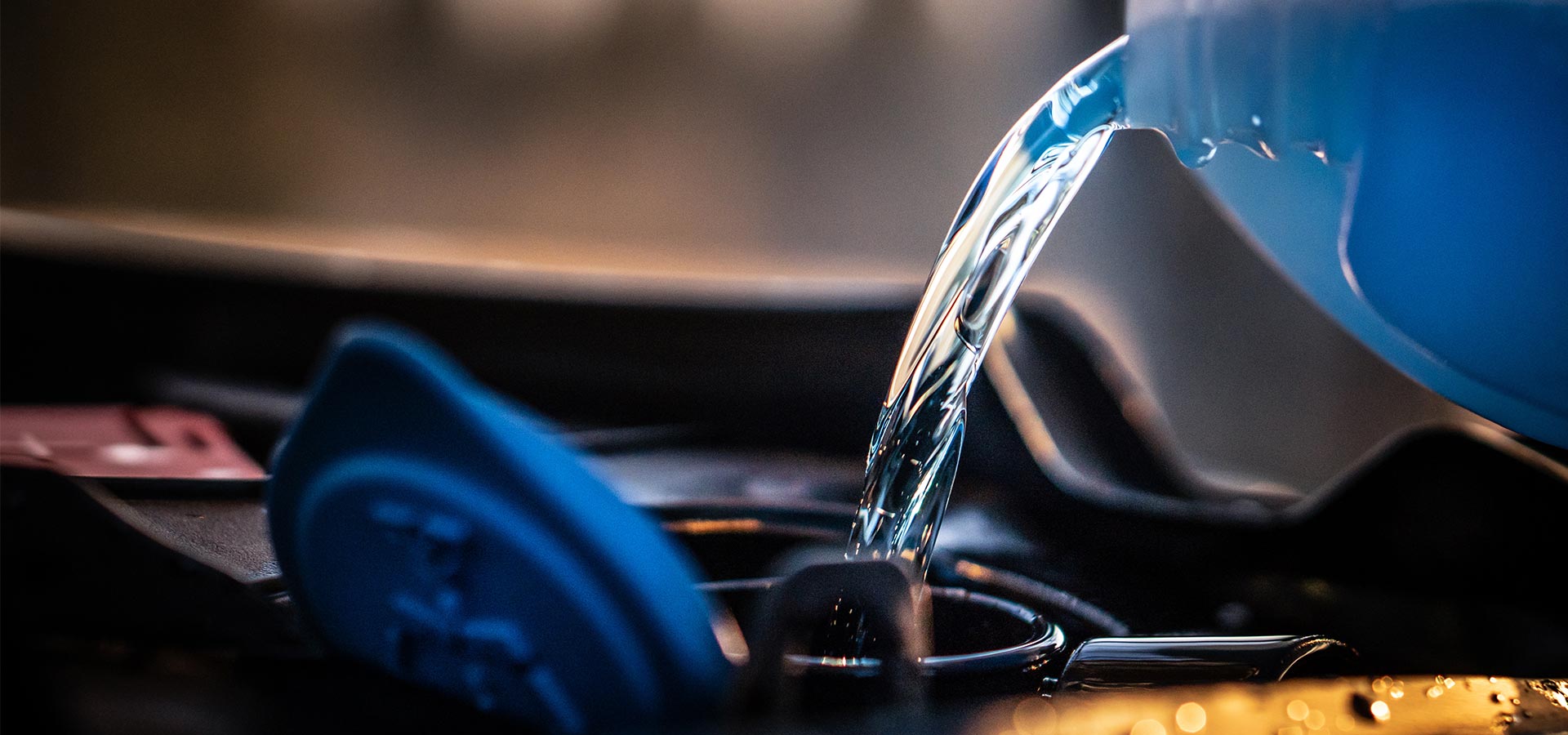 Ansicht einer Kühlflüssigkeit, die in die dafür vorgesehene Öffnung am Motor gegossen wird