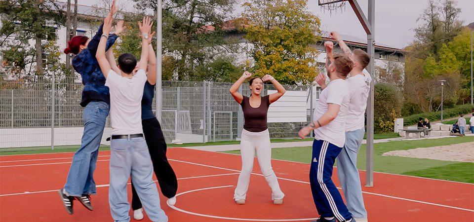 Abbildung einer Gruppe jugendlicher, die zusammen Basketball spielt