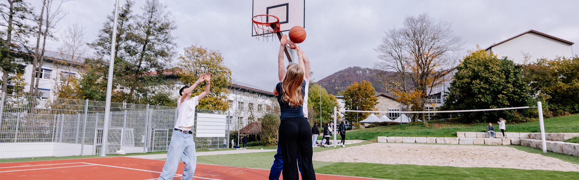 Abbildung einer Gruppe jugendlicher, die zusammen Basketball spielt