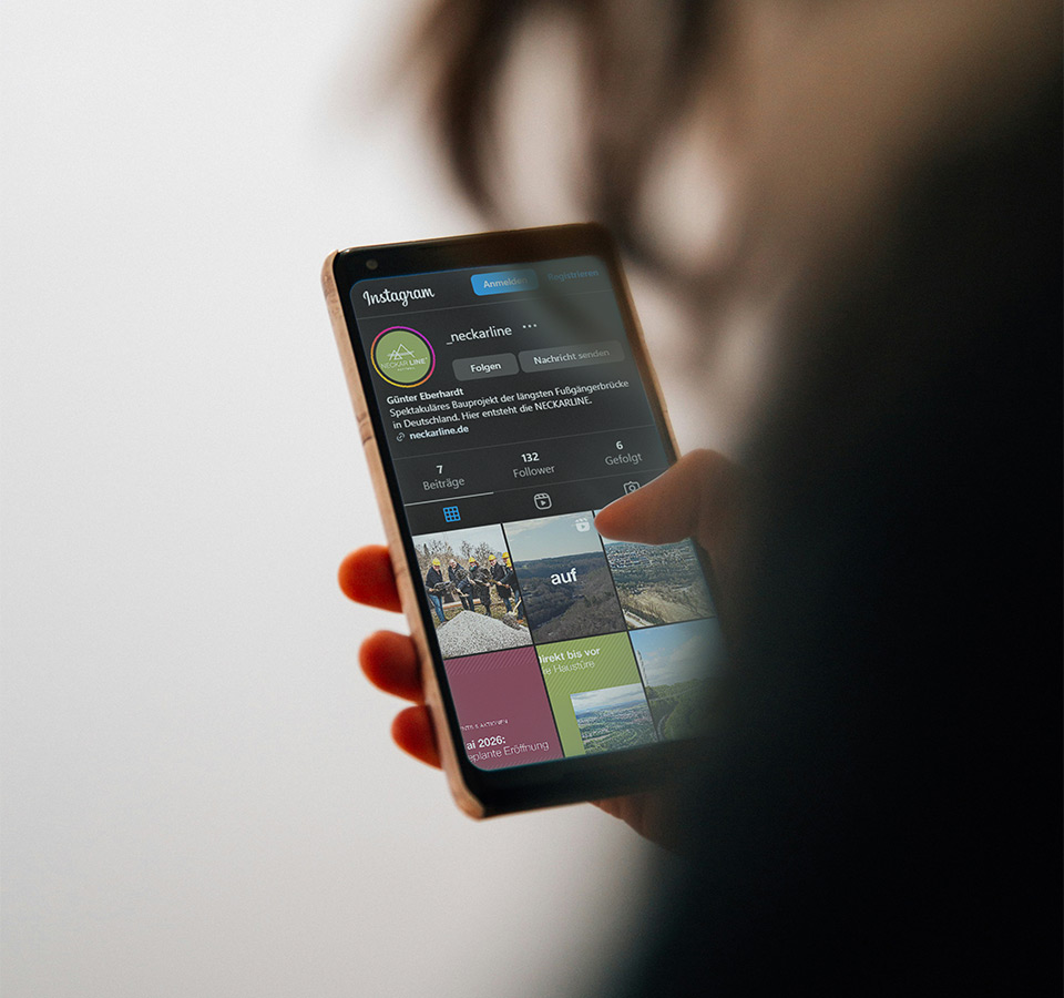 Abbildung einer Person, die ein Smartphone in der Hand hält, auf dem der Instagram-Account der NECKARLINE zu sehen ist.