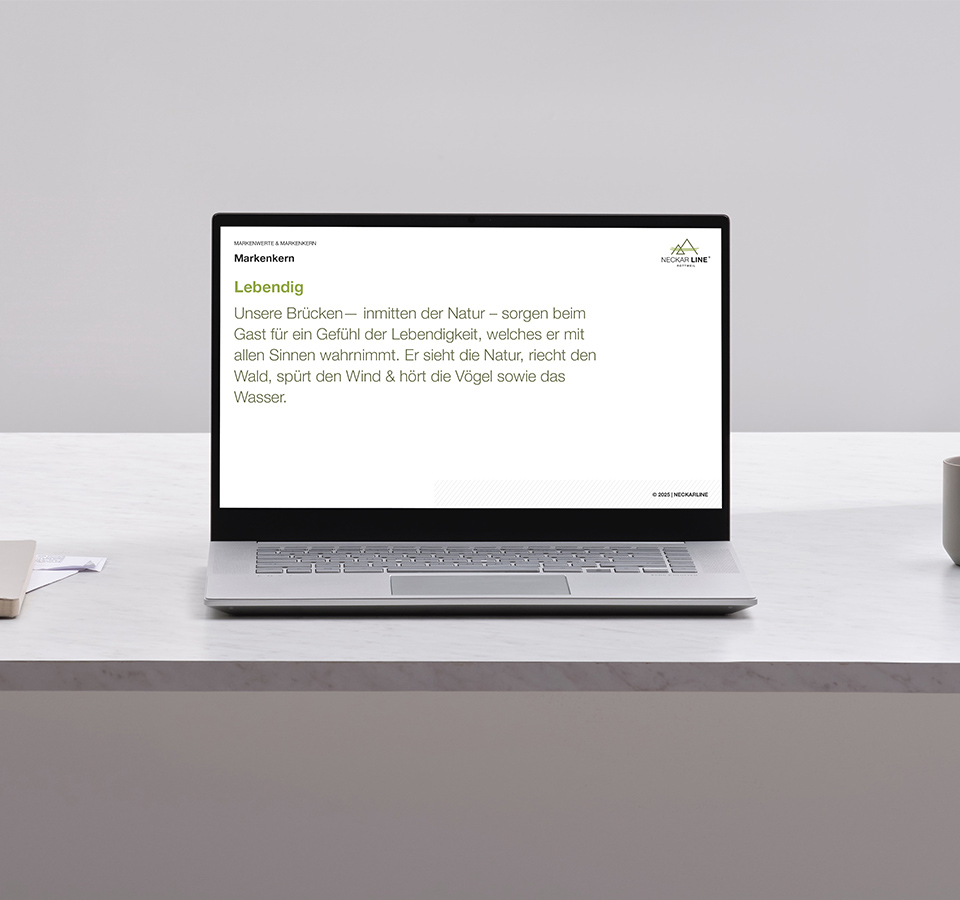 Abbildung eines Laptops auf dem eine Folie des Brand Books der NECKARLINE zu sehen ist.