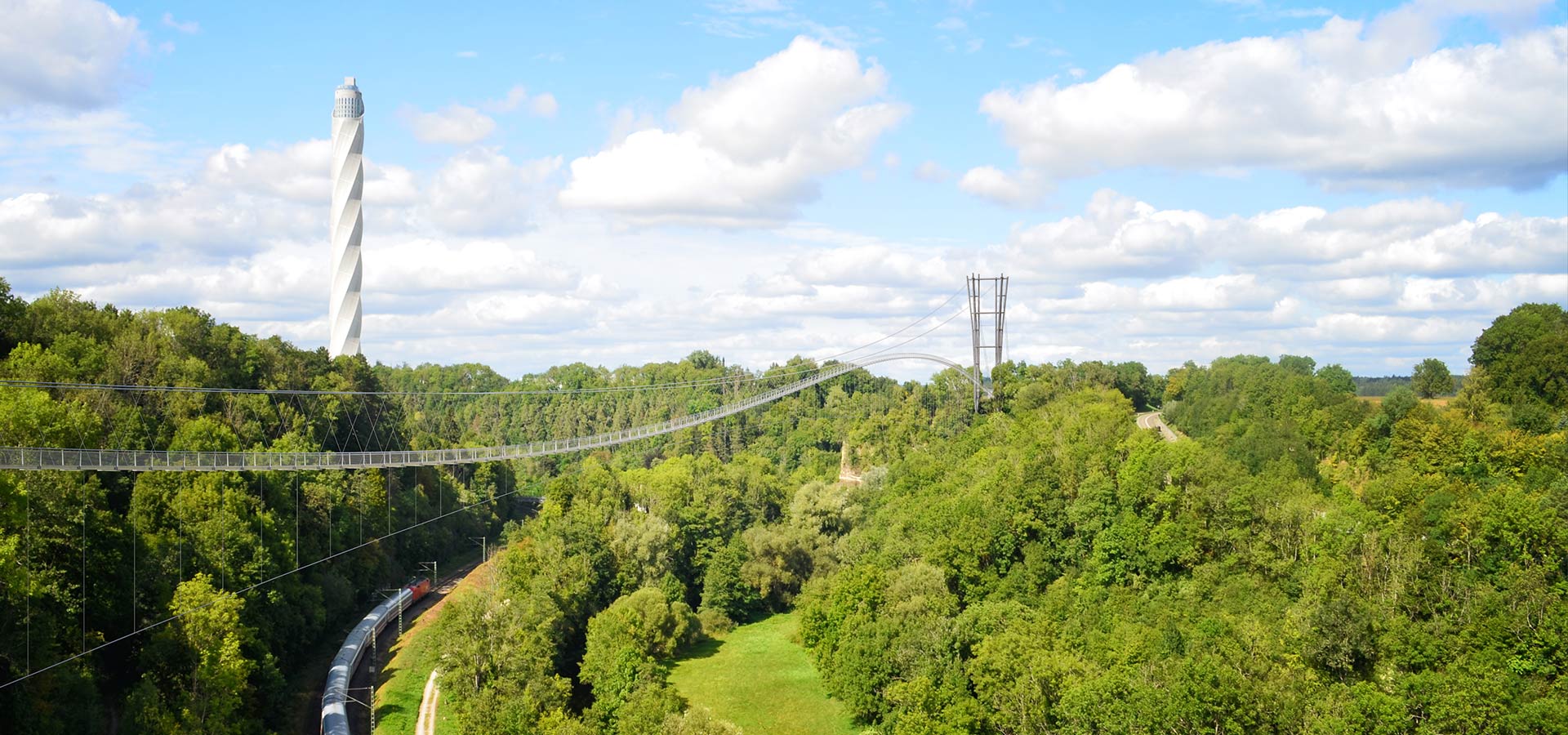 Abbildung eines 3D-Renderings der NECKARLINE über einem Mischwald und einer Bahn.