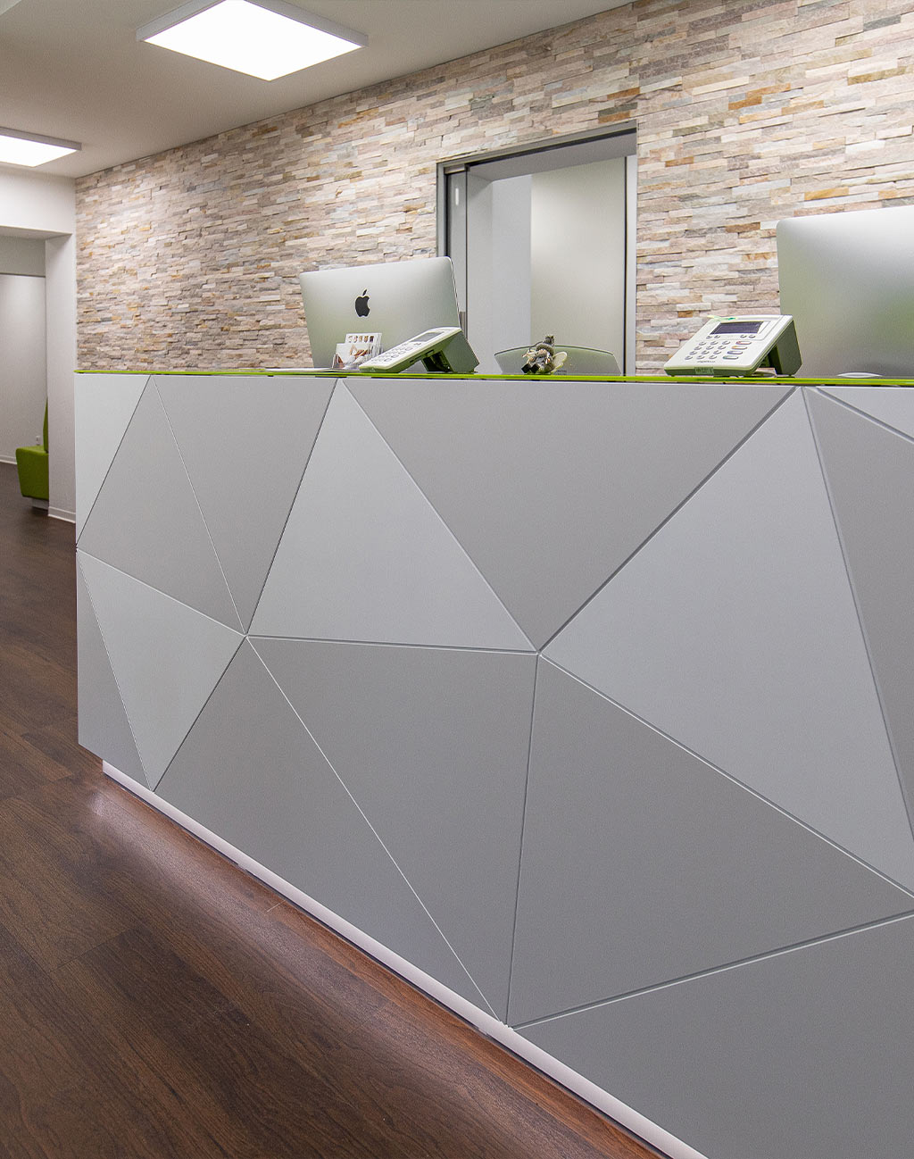 Empfangstheke in Praxisraum mit iMac Computern