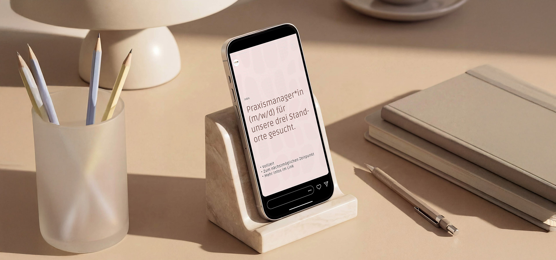 Smartphonebildschirm zeigt Stellenbeschreibung, das Smartphone liegt auf Ablage auf Schreibtisch mit