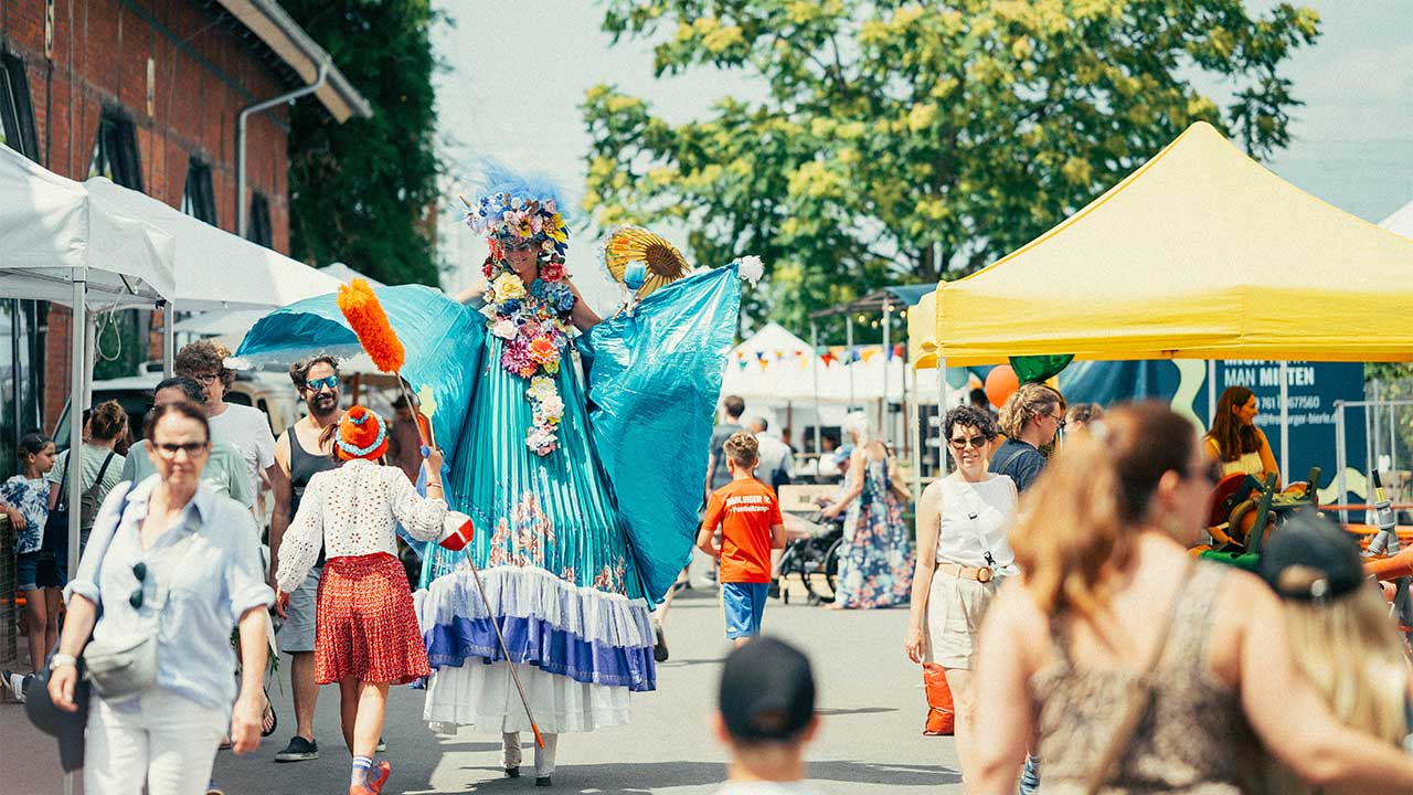 Abbildung einer Frau auf Stelzen auf dem Lokhallenfest 2026