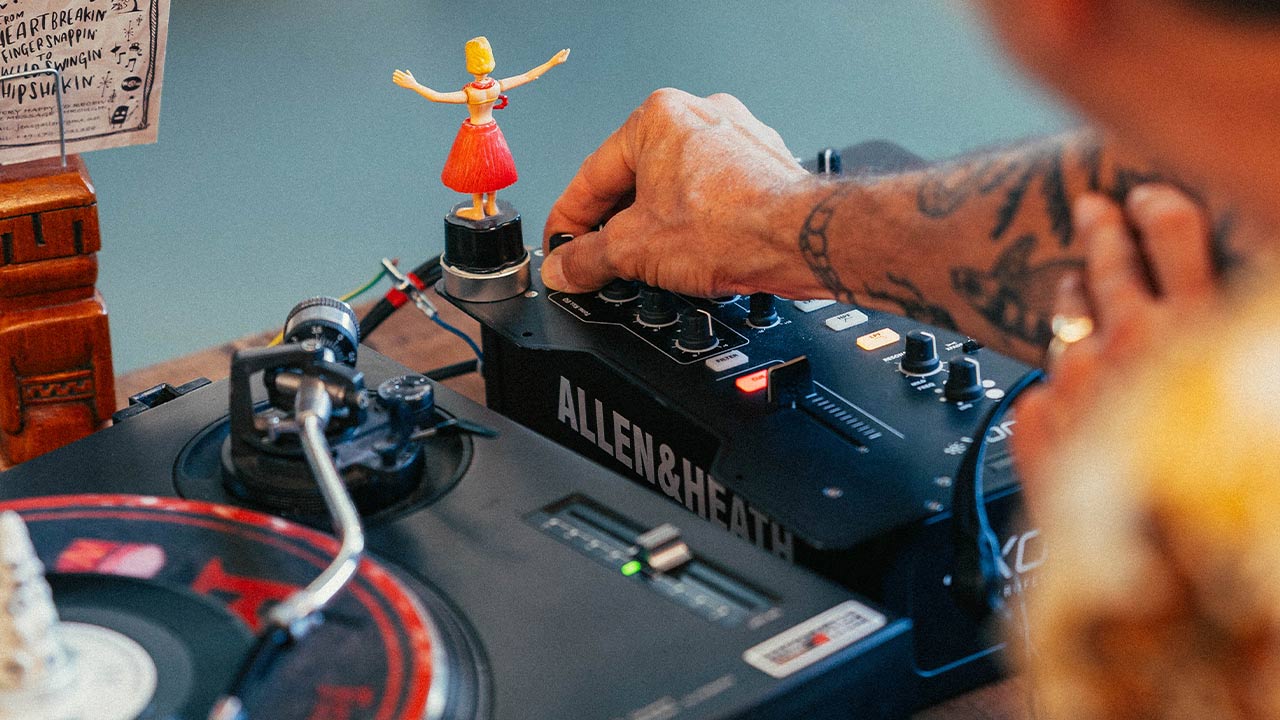 Abbildung einer Männerhand, die ein DJ-Pult bedient